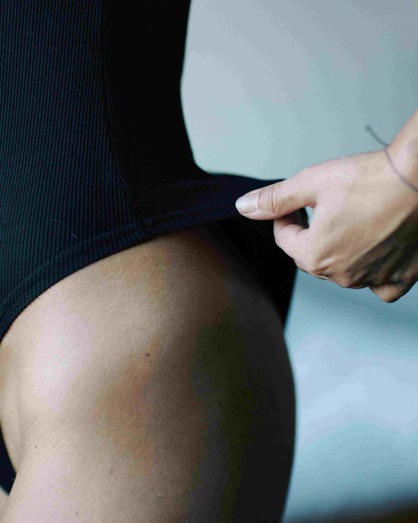 Black bodysuit with open back. Ribbed. Long sleeves, 2-button neckline. VERSATILE.