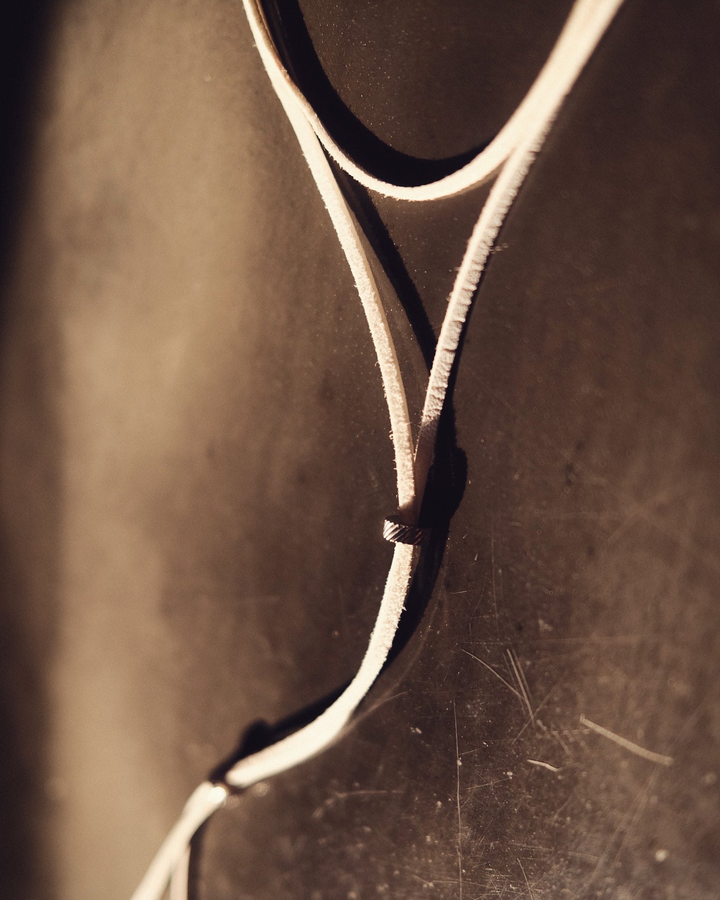 Un lien blanc éclatant en cuir vegan, ponctué de perles argentées en acier inoxydable. Pur, discret, minimal.