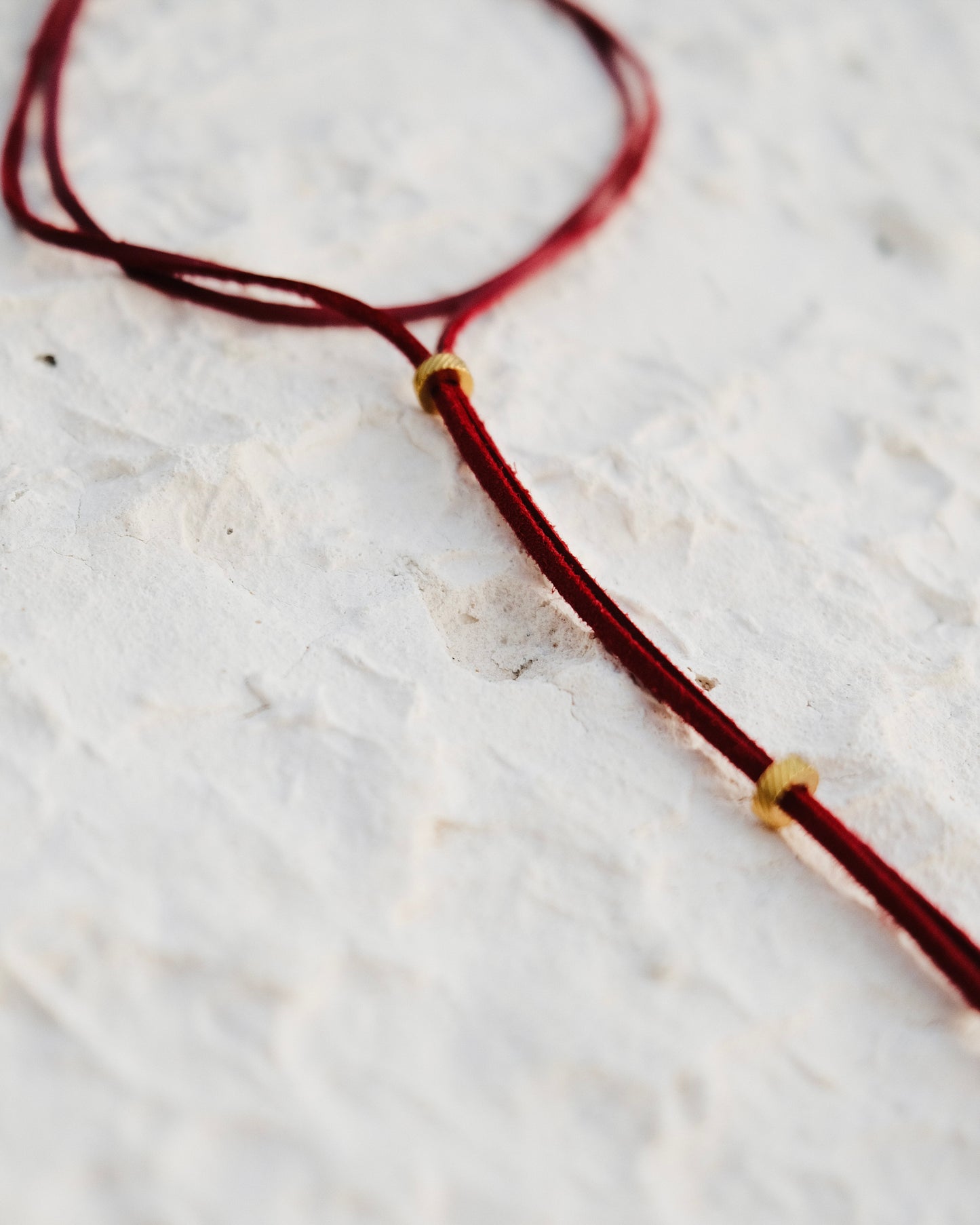 Un lien Carmin en cuir vegan, rehaussé de perles en acier inoxydable. Brûlant, affirmé, hypnotique.